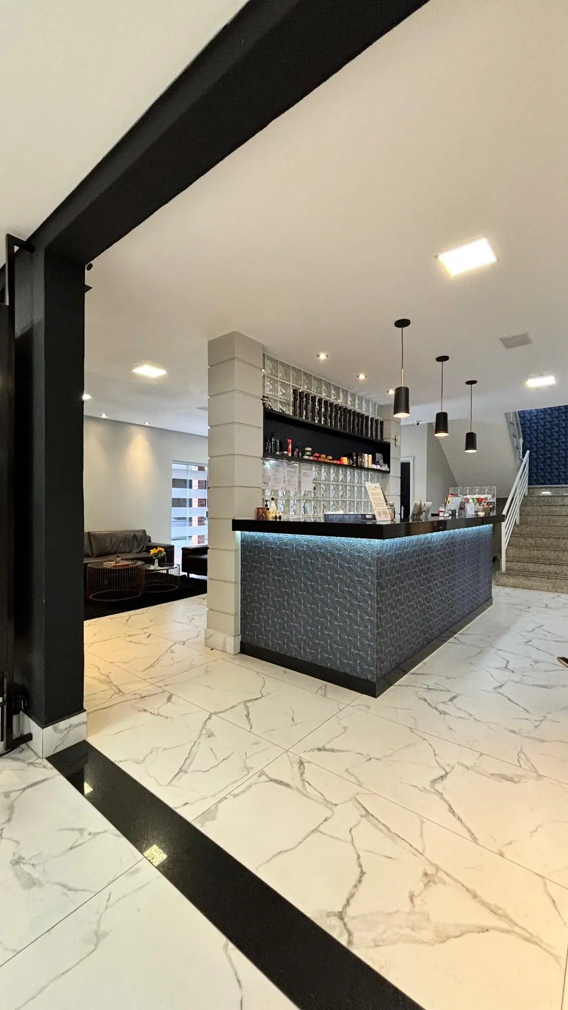 Bar da Lottus visto da entrada, com balcão e luminárias pendentes