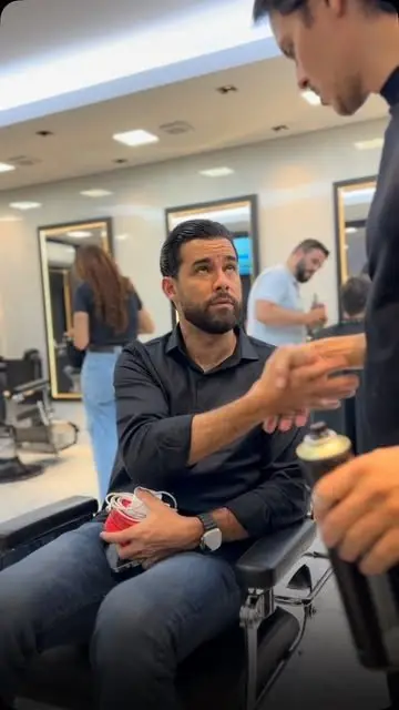 Cliente de camisa preta na cadeira, com corte social